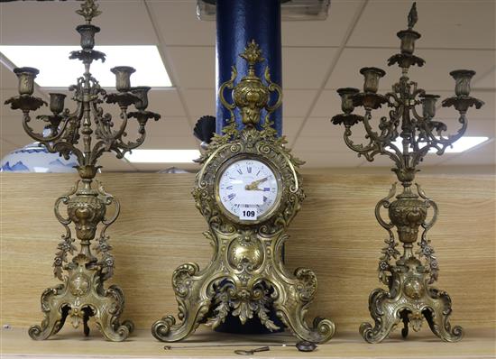 An early 20th century French cast brass three piece clock garniture H.69cm.